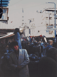 Marktstand mit Verkäufer,
im Hintergrund das Minarett der Yeni Cami
